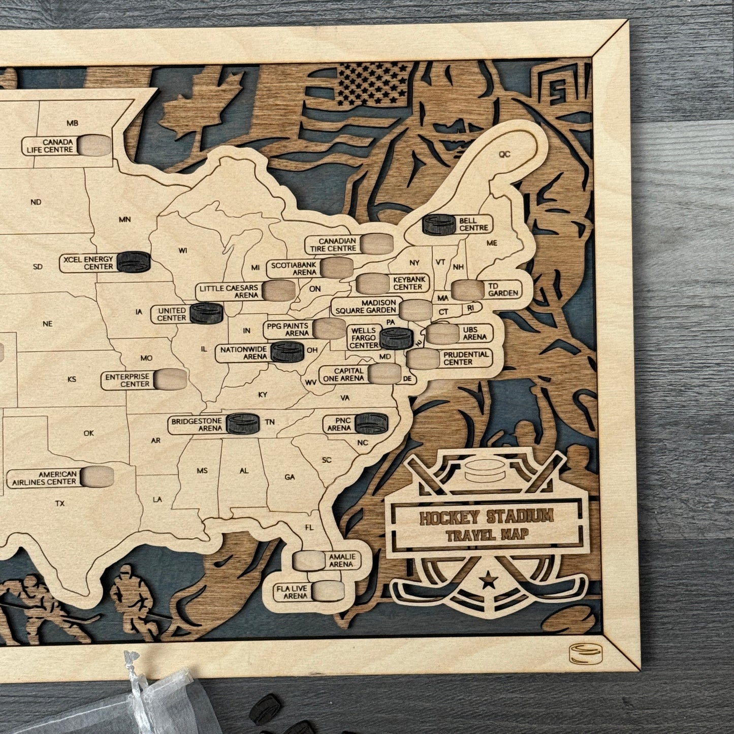 Wooden travel map of hockey stadiums with cut-out hockey pucks on a wooden surface.