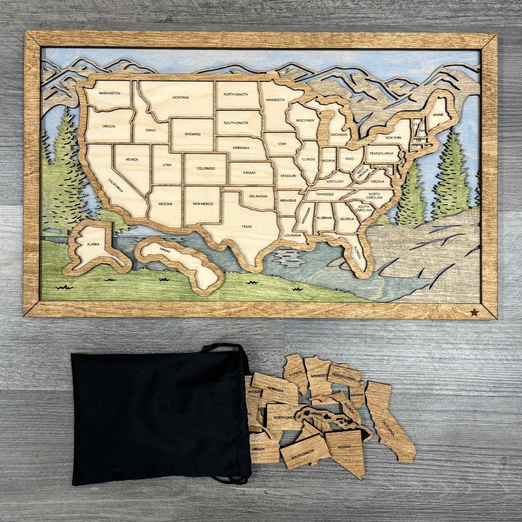 Wooden map of the United States on a wooden surface with a black bag and scattered pieces.